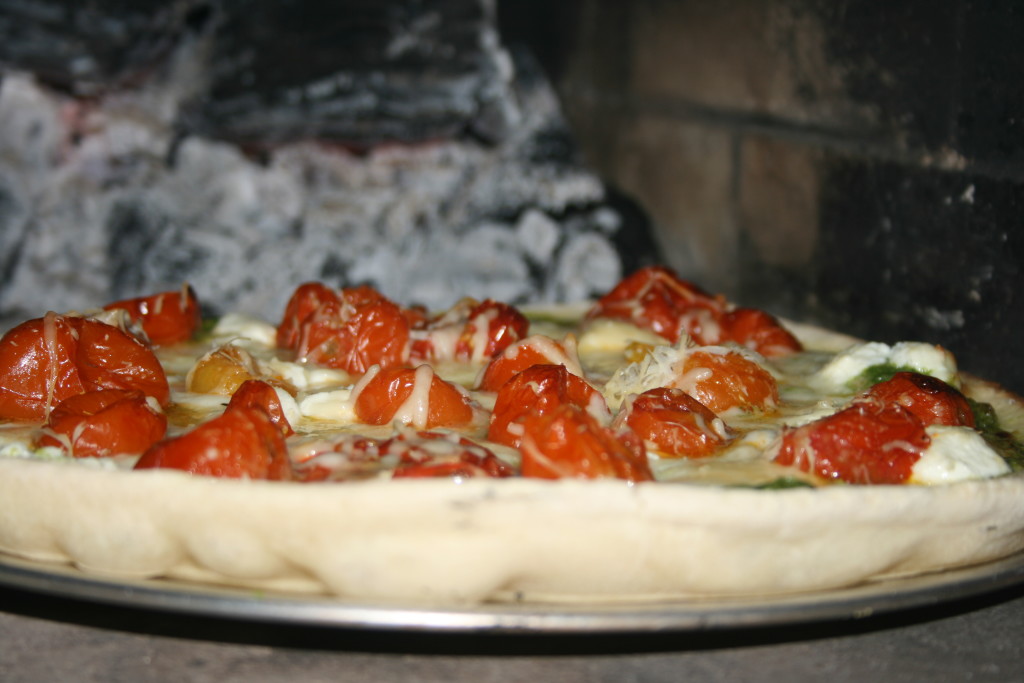 Pesto Pizza with Roasted Tomatoes and Caramelized Onions in Pizza Oven